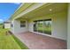 Covered lanai with brick pavers and sliding glass doors at 15512 Greenwood Ave, Port Charlotte, FL 33981