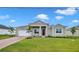 House exterior with a landscaped lawn and paver driveway at 15512 Greenwood Ave, Port Charlotte, FL 33981