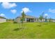Spacious backyard with grassy lawn and young trees at 15512 Greenwood Ave, Port Charlotte, FL 33981