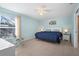 Bright bedroom with blue walls, tiled floors, ceiling fan, and large window at 7106 Parnell Ter, Englewood, FL 34224