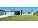 One-story light blue house with attached garage and palm trees at 9267 Waldrep St, Port Charlotte, FL 33981