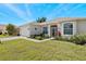 House exterior with a two-car garage and manicured lawn at 24449 Manchester Trl, Punta Gorda, FL 33980