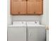 Bright laundry room with washer, dryer, and upper cabinets at 24449 Manchester Trl, Punta Gorda, FL 33980