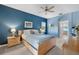 Serene bedroom with light wood furniture, blue walls, and access to a private bathroom at 24449 Manchester Trl, Punta Gorda, FL 33980