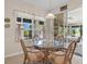 Bright breakfast nook features a glass table and wicker chairs, leading to a screened patio at 24449 Manchester Trl, Punta Gorda, FL 33980