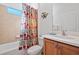 Clean bathroom with a tub shower, vanity, and geometric shower curtain at 24449 Manchester Trl, Punta Gorda, FL 33980