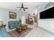 Open living room with view into kitchen, teal couches, and built-in entertainment center at 16446 Belo Ct, Punta Gorda, FL 33955