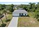 Aerial showing landscaped front yard, grey roof, and white exterior of new home at 2049 Delta St, Port Charlotte, FL 33952