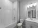 Bathroom view with white subway tiling around the tub and white vanity with quartz countertop at 2049 Delta St, Port Charlotte, FL 33952