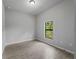Bedroom view with neutral gray walls and gray wood-look tiling. A window provides natural light at 2049 Delta St, Port Charlotte, FL 33952