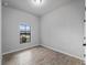 Bedroom with neutral gray walls and gray wood-look tiling. A window provides natural light at 2049 Delta St, Port Charlotte, FL 33952