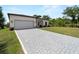 Long paved driveway leading to a well-kept home with a pristine lawn and attached garage at 2049 Delta St, Port Charlotte, FL 33952