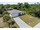 New construction home featuring a paver driveway, attached garage and tropical landscaping at 2049 Delta St, Port Charlotte, FL 33952