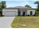 Charming single-story home featuring a paved driveway, attached garage, and a well-kept lawn at 2049 Delta St, Port Charlotte, FL 33952
