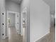 Hallway view with neutral gray walls and gray wood-look tiling with white trim on the doorways at 2049 Delta St, Port Charlotte, FL 33952