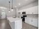Bright kitchen with stainless appliances, white cabinetry, and a center island with sink at 2049 Delta St, Port Charlotte, FL 33952