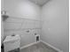 Laundry room with utility sink, wire rack and gray walls and gray wood-look tiling at 2049 Delta St, Port Charlotte, FL 33952