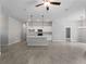 Spacious living room with wood-look tile, ceiling fan, and open to kitchen area at 2049 Delta St, Port Charlotte, FL 33952