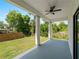 Covered patio with ceiling fan overlooks a grassy backyard and wood fence at 2049 Delta St, Port Charlotte, FL 33952