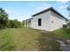 Modern home featuring a well-maintained lawn and sleek architectural design under a bright blue sky at 2049 Delta St, Port Charlotte, FL 33952