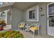 Small patio with white wicker chairs and yellow cushions at 3310 Loveland Blvd # 1502, Punta Gorda, FL 33980