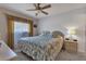 King-size bed, nightstand, ceiling fan, and window with curtains in a well-lit bedroom at 3310 Loveland Blvd # 1502, Punta Gorda, FL 33980