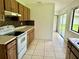 Bright kitchen with wood cabinets, white appliances, and access to backyard at 1160 Belkton Ave, Port Charlotte, FL 33948
