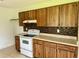Kitchen with wood cabinets and white appliances at 1160 Belkton Ave, Port Charlotte, FL 33948