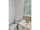 Bathroom with white vanity, toilet, and tiled backsplash at 1160 Belkton Ave, Port Charlotte, FL 33948