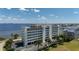 Waterfront condo building with an American flag, palm trees, and parking lot at 1500 Park Beach Cir # 3C, Punta Gorda, FL 33950