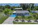 Charming home with a blue painted driveway, manicured lawn, lush landscaping, and a detached garage at 27437 Dutch Ave, Punta Gorda, FL 33982