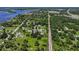 An aerial view displays a home near train tracks, surrounded by lush greenery and other homes at 27437 Dutch Ave, Punta Gorda, FL 33982