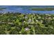 An aerial view of a home near a body of water and surrounded by lush, green trees at 27437 Dutch Ave, Punta Gorda, FL 33982