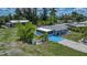 Charming home with a blue painted driveway, manicured lawn, lush landscaping, and a detached garage at 27437 Dutch Ave, Punta Gorda, FL 33982