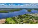An aerial view shows a waterfront home surrounded by lush greenery with a waterway and mangrove islands at 27437 Dutch Ave, Punta Gorda, FL 33982