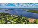 An aerial view features a waterfront home with a pier and dock, surrounded by lush greenery at 27437 Dutch Ave, Punta Gorda, FL 33982