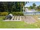 Spacious backyard with a greenhouse, raised garden beds, and lush green lawn at 27437 Dutch Ave, Punta Gorda, FL 33982