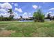 Expansive backyard with lush green grass and tropical landscaping surrounding a charming single-story home at 27437 Dutch Ave, Punta Gorda, FL 33982