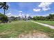 Wide backyard view showcasing a well-maintained lawn and the rear of the cozy single-story residence at 27437 Dutch Ave, Punta Gorda, FL 33982