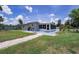 Backyard featuring a screened-in porch, stone pathway, and lush green lawn, perfect for outdoor enjoyment at 27437 Dutch Ave, Punta Gorda, FL 33982