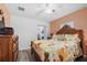 Inviting bedroom with wood-look flooring, a floral patterned bedspread, and access to the laundry area at 27437 Dutch Ave, Punta Gorda, FL 33982