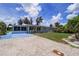 Charming home with gravel driveway, lush lawn, and a cozy, enclosed porch is displayed on a sunny day at 27437 Dutch Ave, Punta Gorda, FL 33982