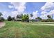 Well-maintained property with lush green lawns, mature palm trees, and a detached garage building at 27437 Dutch Ave, Punta Gorda, FL 33982