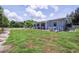A charming home with a patio and walkway is showcased on a manicured lawn with beautiful blue accents at 27437 Dutch Ave, Punta Gorda, FL 33982