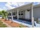 Inviting home featuring a cozy front porch with ample seating and charming curb appeal at 27437 Dutch Ave, Punta Gorda, FL 33982