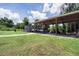 Large covered parking area with multiple vehicles and equipment storage, set on a spacious lawn at 27437 Dutch Ave, Punta Gorda, FL 33982