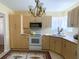 Kitchen with light wood cabinets, white appliances, and patterned rug at 22239 Midway Blvd, Port Charlotte, FL 33952