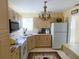 Galley kitchen with beige cabinets, updated appliances, and a tiled floor at 22239 Midway Blvd, Port Charlotte, FL 33952