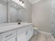 This bathroom has a vanity with marble countertop, white cabinetry, and a tiled shower at 13348 Rayburn Ln, Port Charlotte, FL 33981