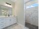 Modern bathroom featuring a vanity with white cabinets and a walk-in shower with marble-look tile at 13348 Rayburn Ln, Port Charlotte, FL 33981